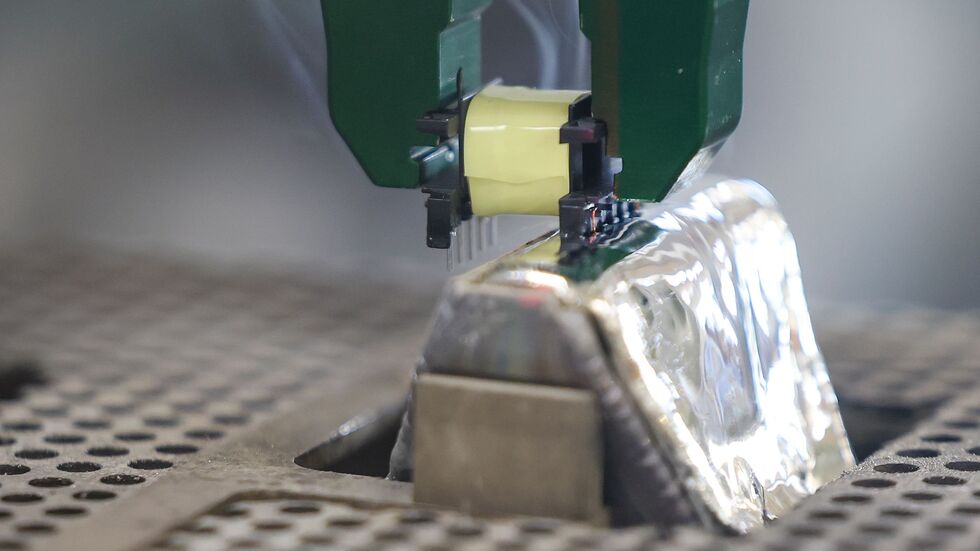 Per Roboter-Greifarm werden die Pins einer Spule in ein 400 Grad heißes Zinnbad getaucht. Per Roboter-Greifarm werden die Pins einer Spule in ein 400 Grad heißes Zinnbad getaucht.