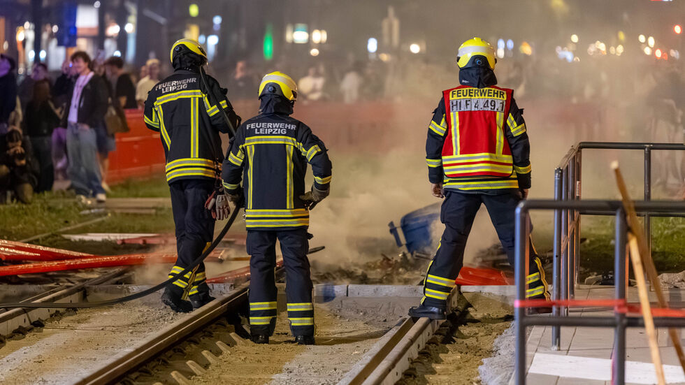 Feuerwehrleute beim Löscheinsatz am Rande des Karli-Bebens am Samstagabend in Leipzig.