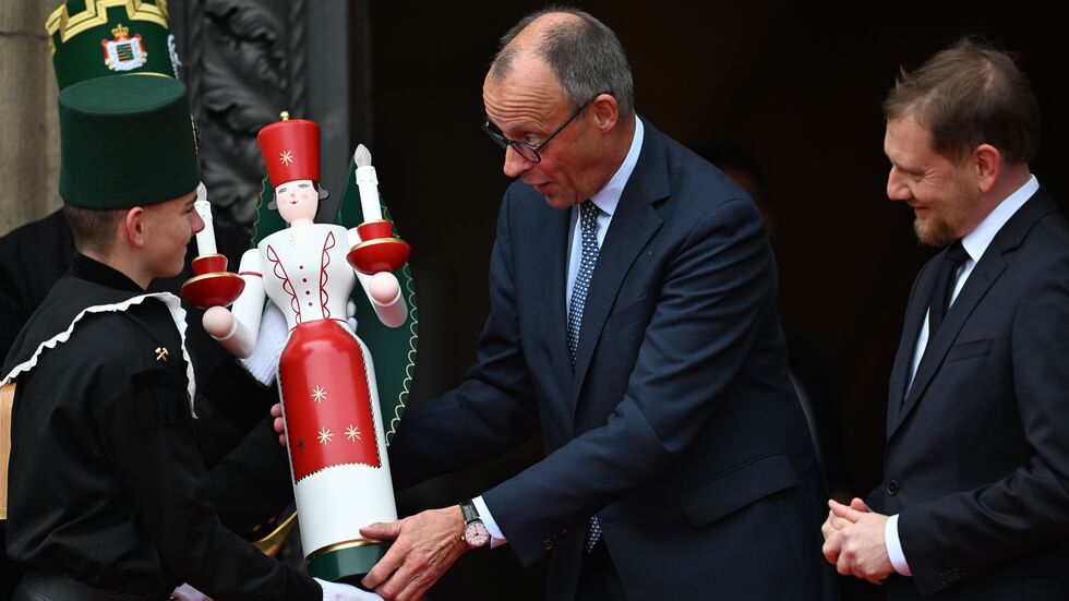 Bundeskanzler Friedrich Merz (CDU) erhält neben Ministerpräsident Michael Kretschmer (CDU, r) bei seiner Ankunft vor der Staatskanzlei eine erzgebirgische Engelsfigur.  Bundeskanzler Friedrich Merz (CDU) erhält neben Ministerpräsident Michael Kretschmer (CDU, r) bei seiner Ankunft vor der Staatskanzlei eine erzgebirgische Engelsfigur.