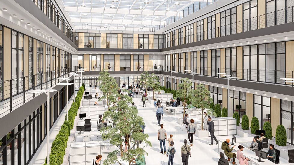 Die Halle ist lichtdurchflutet, wir sehen offene Büros und Grünpflanzen.