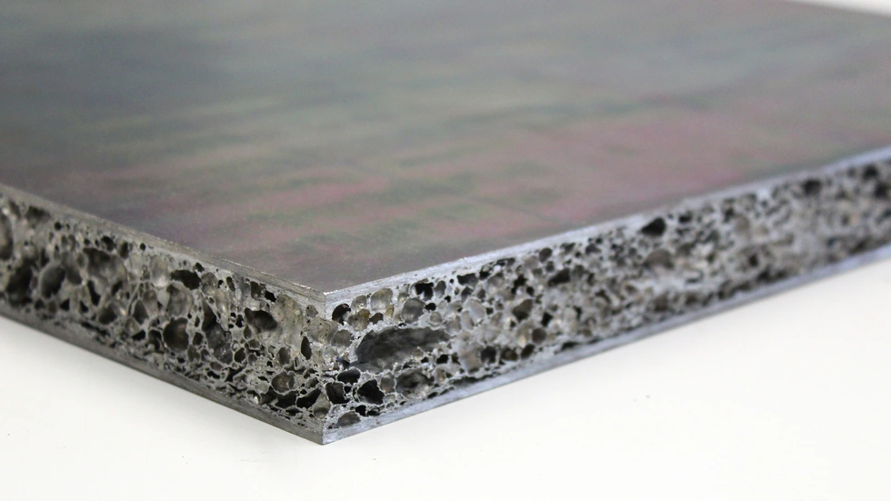 Sieht aus wie ein Metallschwamm: Zwischen zwei dünnen Blechen steckt der leichte Aluminiumschaum des Fraunhofer IWU. Die Sandwichplatte soll rund 30 Prozent Gewicht sparen.
Sieht aus wie ein Metallschwamm: Zwischen zwei dünnen Blechen steckt der leichte Aluminiumschaum des Fraunhofer IWU. Die Sandwichplatte soll rund 30 Prozent Gewicht sparen.