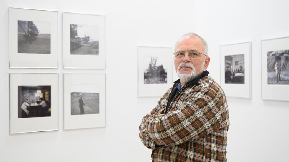 Fotograf Jürgen Matschie, steht in der Ausstellung "Schicht. Umbrüche im Revier" in der Energiefabrik Knappenrode vor seinen Fotoserien "Visionär I" und "Visionär II" aus dem Jahr 1989. Ab dem 1. Mai 2022 sind in der historischen Schaltzentrale der ehemaligen Brikettfabrik Archiv- und aktuelle Aufnahmen der ehemaligen Braunkohleregion von der Künstlergruppe ASA zu sehen.