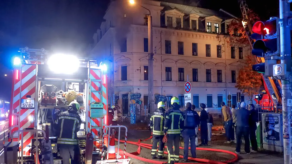 Anwohner und Rettungskräfte vor dem qualmenden Haus.