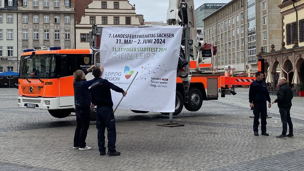 Auf dem Markt: Das Webeplakat fürs 31. Leipziger Stadtfest, dass 2024 erstmals zusammen mit dem Landesfeuerwehrtag veranstaltet wird.