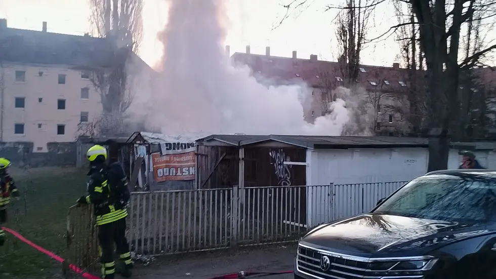 Von dem Garagenhof an der Holbergstraße in Neulindenau steigt eine Rauchwolke auf.