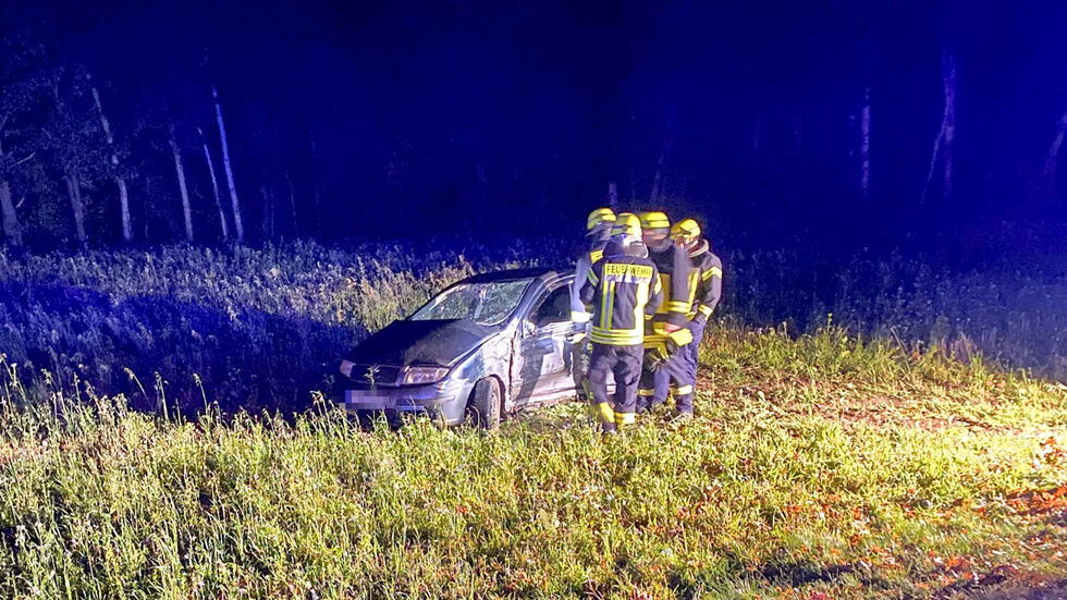 Die Einsatzkräfte bei dem verunfallten Auto.