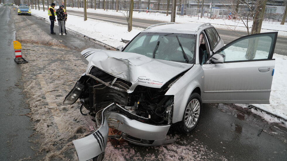 Der kaputte Audi auf der Messe-Allee - der Fahrer (hinten mit zwei Polizisten) wurde zum Glück nur leicht verletzt.