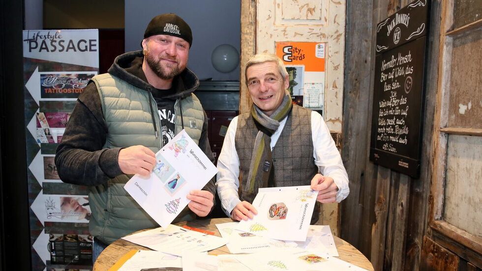 Randy Engelhard (l.) und Hans-Jürgen Melle lesen sich die Wunschzettel der Kinder durch.