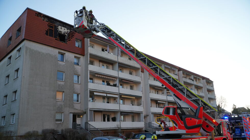 Feuerwehrleute auf einer Drehleiter am Brandort.