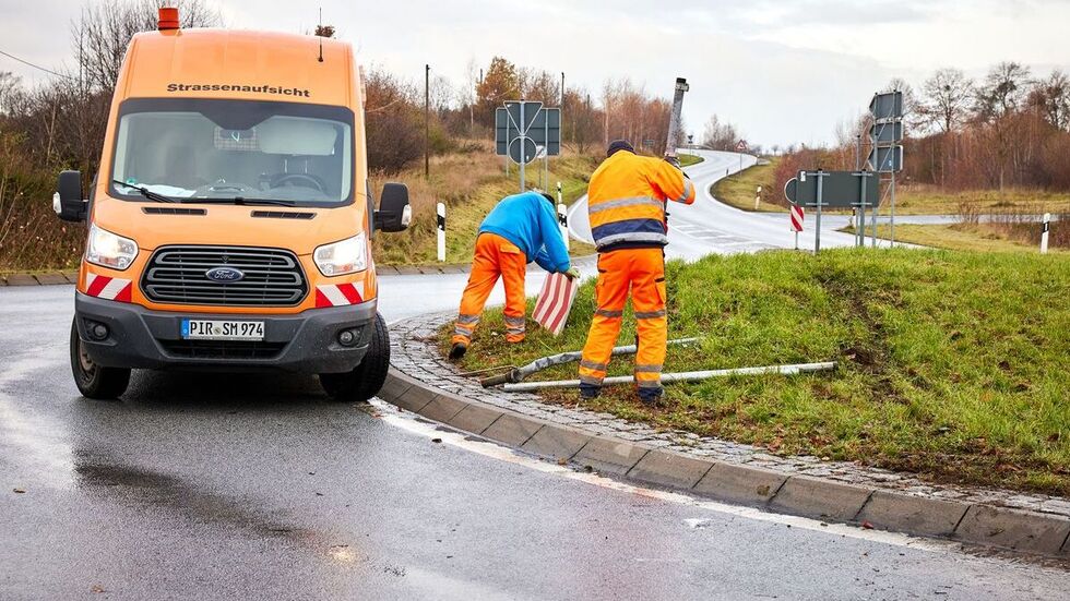 Mitarbeiter der Straßenmeisterei stellen die Schilder wieder auf. 