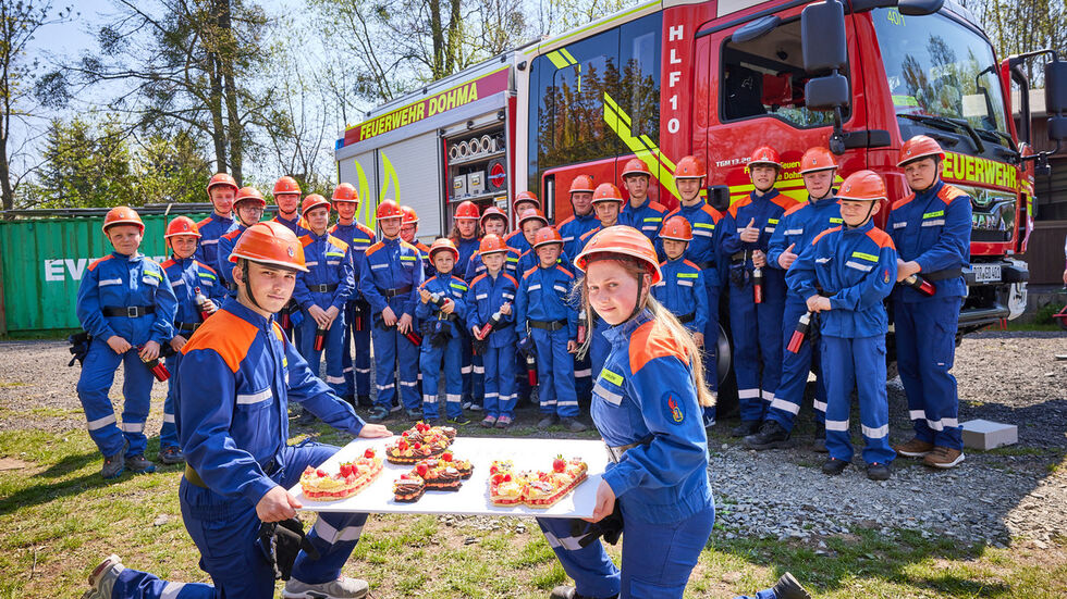 Jugendgruppe der Feuerwehr Dohma - Goes - Cotta präsentiert ihre Geburtstagstorte. 