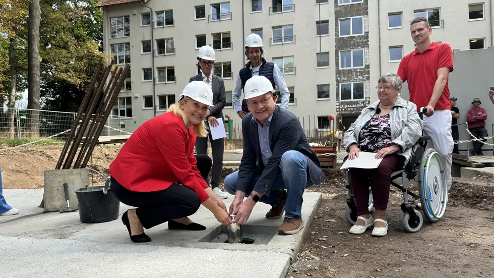Oberbürgermeisterin Constance Arndt und SSH-Geschäftsführer Jens Geigenmüller lassen die Zeitkapsel in die Öffnung hinabgleiten. 