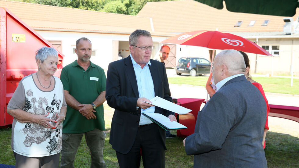 Staatssekretär Gerd Lippold überreicht Hirschfelds Bürgermeister Rainer Pampel den Förderbescheid. 
