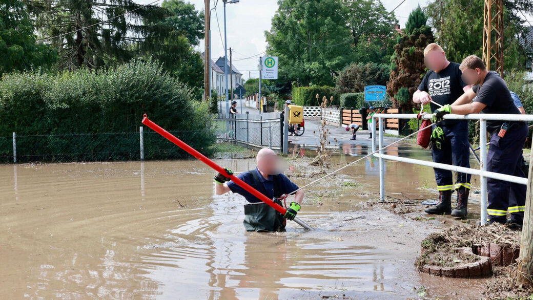 Kameraden der freiwilligen Feuerwehr versuchen den Durchlauf bei der Bahretalstraße frei zu bekommen. 