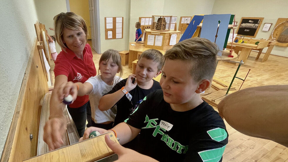 Diana Hübner aus dem Vorstand der ZWG mit den Ferienkindern Marlene, Lenny (Mitte) und Philip im Haus der Entdecker in Reinsdorf.