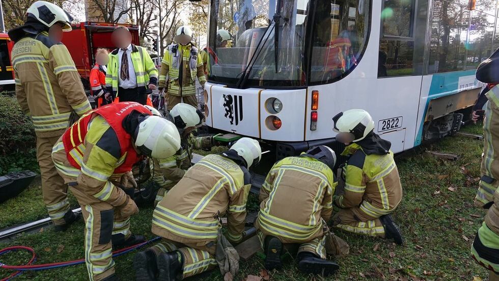 Zahlreiche Feuerwehrleute bringen das Fahrzeug mithilfe schwerer Technik wieder zurück auf die Gleise.
