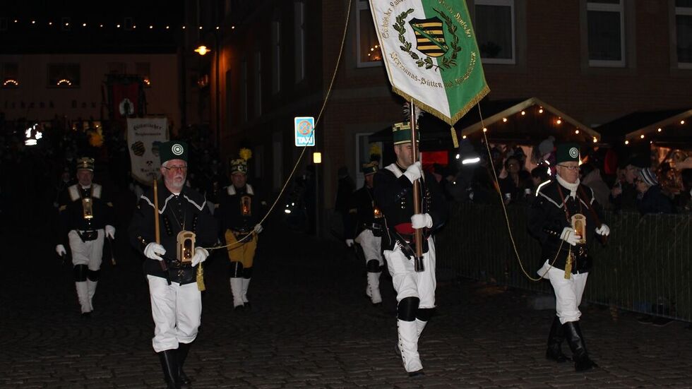 Knapp 500 Trachtenträger maschieren nach Einbruch der Dunkelheit durch Aue.