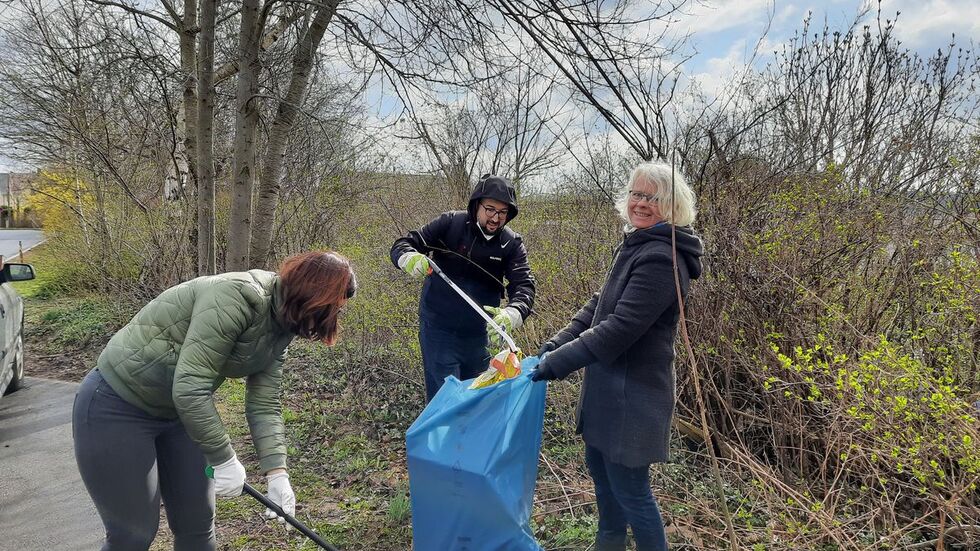 Franziska Degen, Simo Bouti und Katharina Weyandt (v.l.n.r.) säubern beim Frühjahrsputz 2022 das Umfeld der Erstaufnahmeeinrichtung für Flüchtlinge in Ebersdorf.