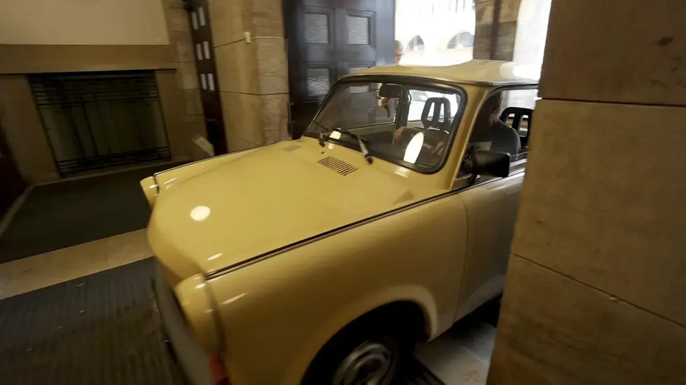 Der ockerfarbene Trabant 1.1 fährt durch den Eingang des Chemnitzer Rathauses ins Foyer. Dort ist er Blickfang der Ausstellung über Carl Hahn.