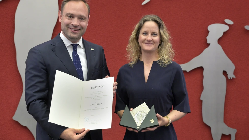 Landtagspräsident Alexander Dierks überreicht Bauunternehmerin Linda Hüttner die Sächsische Verfassungsmedaille. 