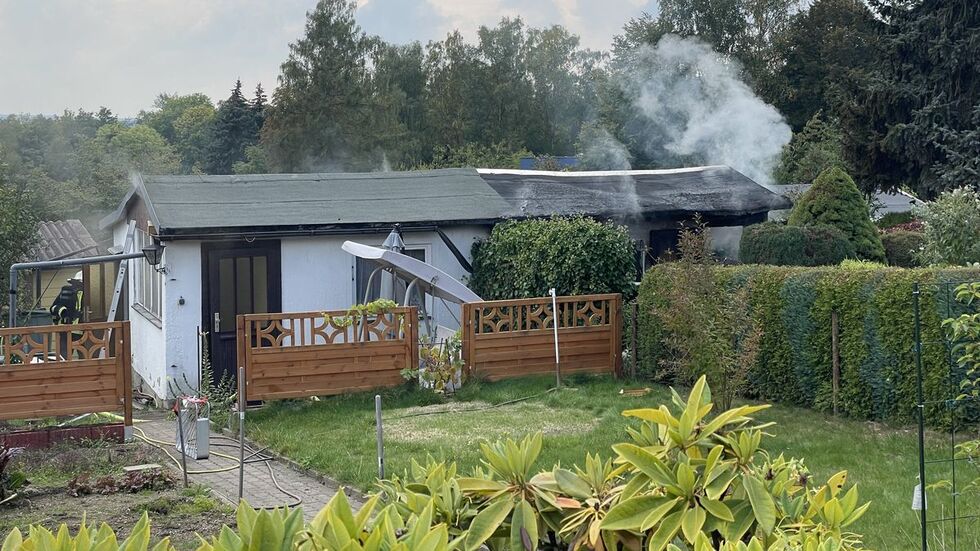 Aus der Laube quillt dichter Rauch.