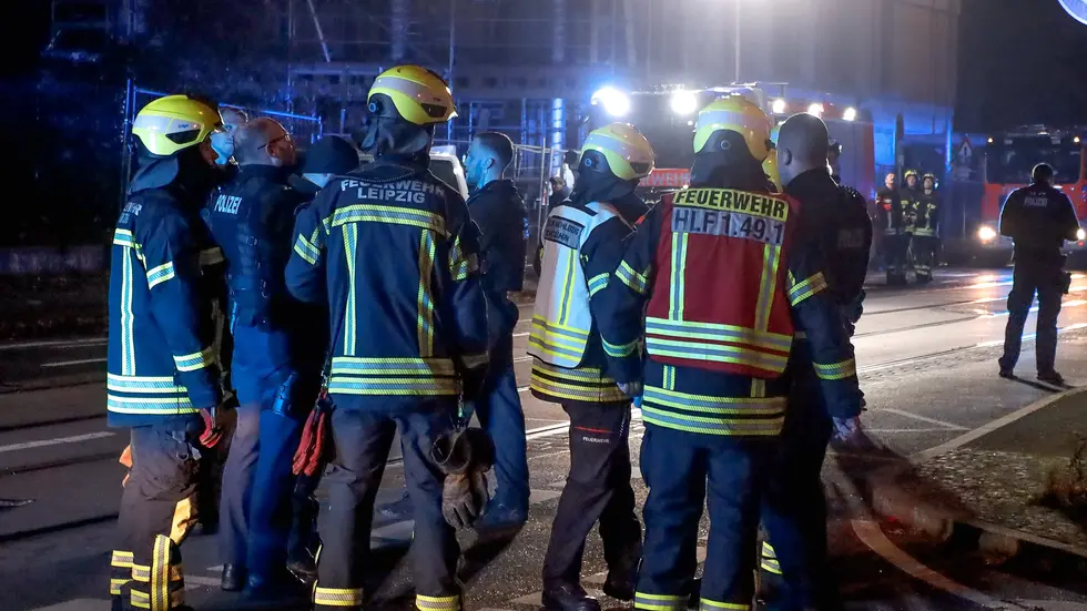 Feuerwehrleute auf der Straße vor dem Wohnhaus.