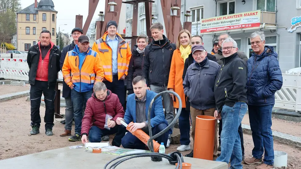 Mitglieder des Stadtmanagements, Schnitzer, Bauleute und die Oberbürgermeisterin beim Versenken der Zeitkapsel