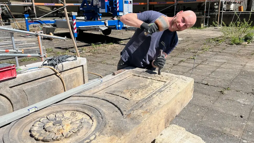 Steinmetz und Bildhauer Thomas Schmid arbeitet Balustradenteile auf 