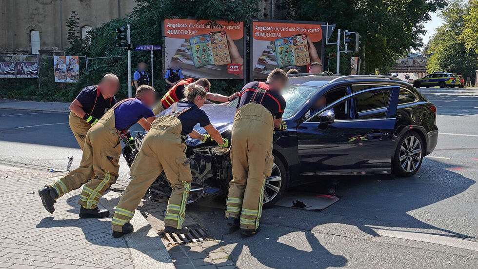 Die Einsatzkräfte schieben den Mazda von der Kreuzung.