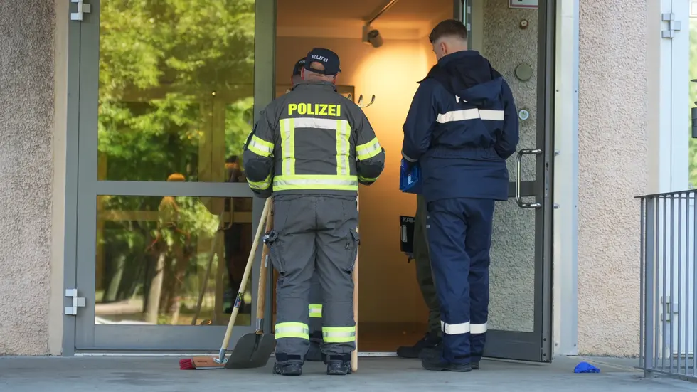 Ermittler am Eingang zu dem Leipziger Hochhaus, in dem der 57-Jährige bei einem Wohnungsbrand ums Leben kam.