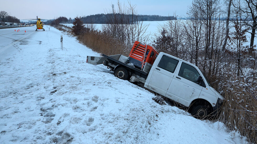 Ein Fahrzeug landete im Straßengraben. Im Hintergrund steht der Rettungshubschrauber.